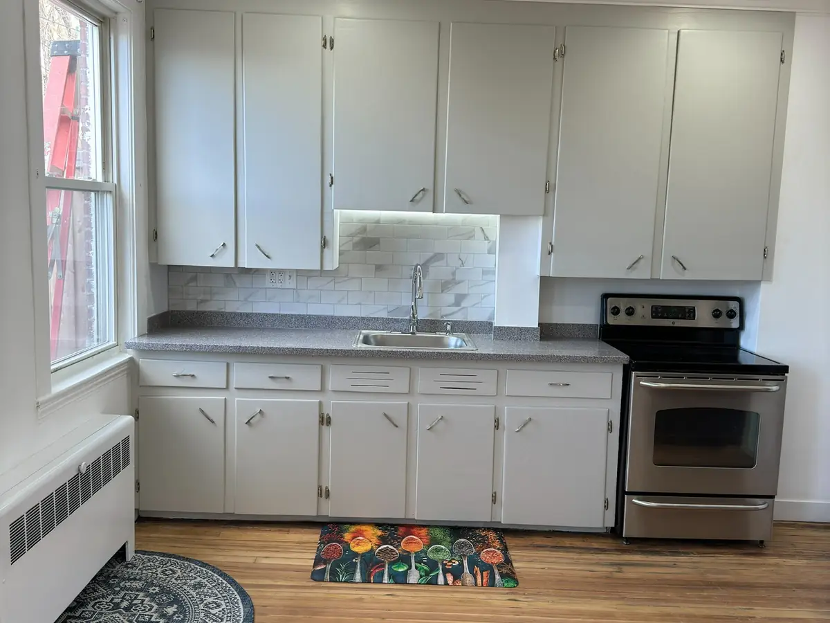 A refitted kitchen lit by recessed ceiling lighting.